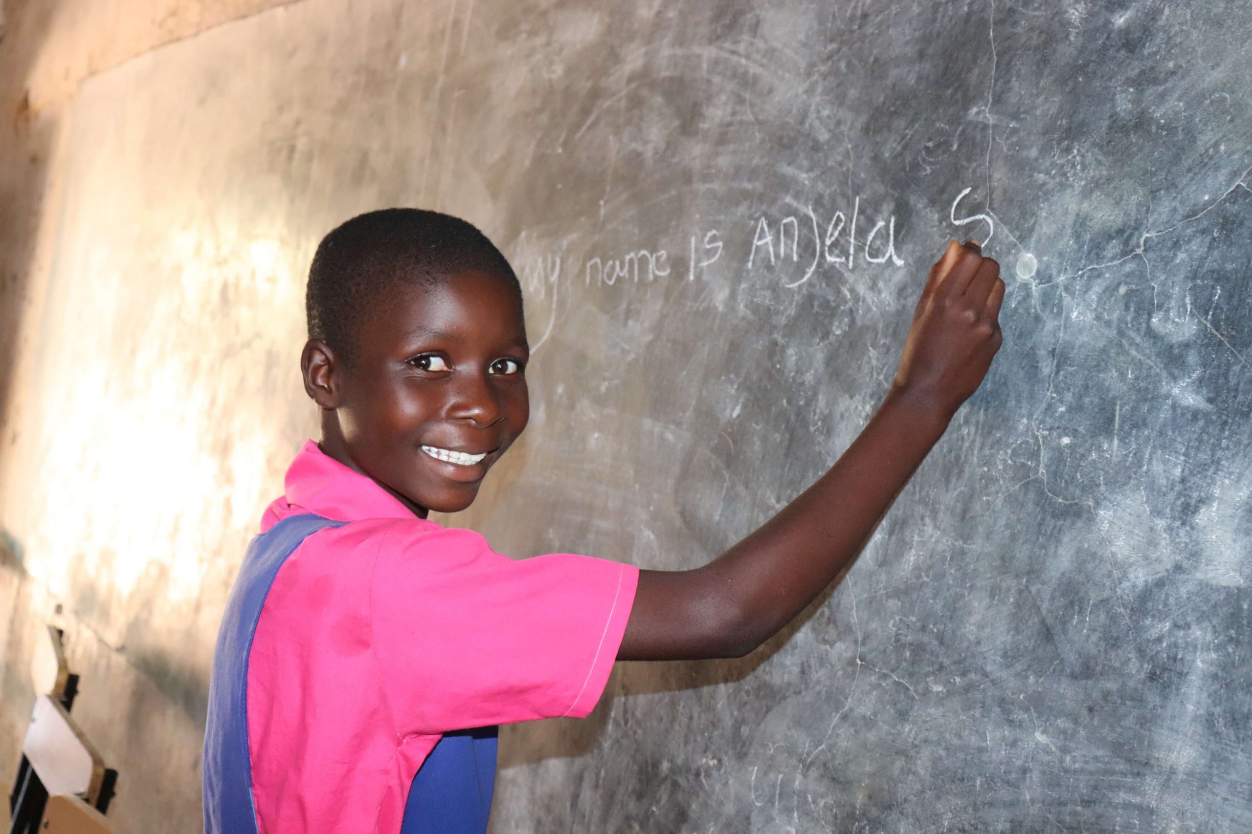 Balaka district, Malawi: Angela writes her name on the classroom blackboard at a primary school in Balaka district, Malawi. Photo credit: Veronica Mwale/Oxfam in Southern Africa