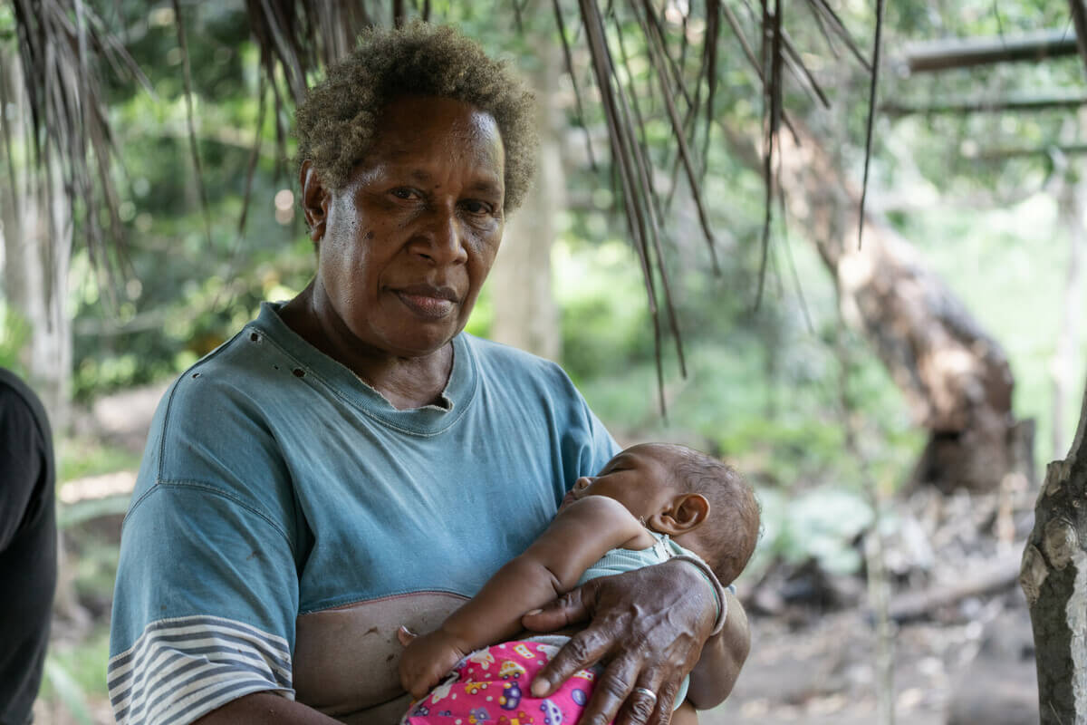 Molpoe, Vanuatu: Pamela with one of her grandchildren. Her home, the village of Molpoe in Vanuatu, was hit by a devastating landslide caused by torrential rain, which has become more frequent due to extreme weather. Photo: Ivan Utahenua/Oxfam