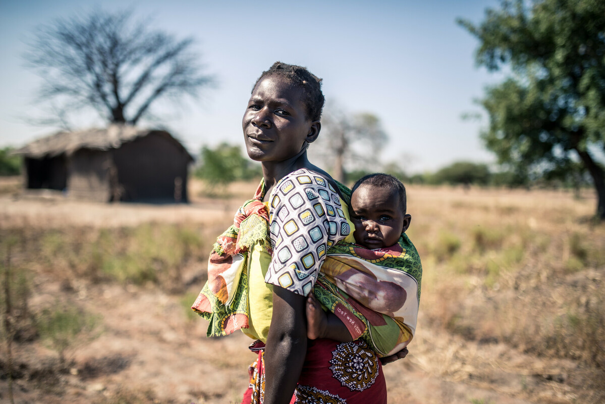 Malawi: Elube (32) stands with her baby in her small plot of farm land. Photo: Aurelie Marrier d'Unienville/Oxfam AUS