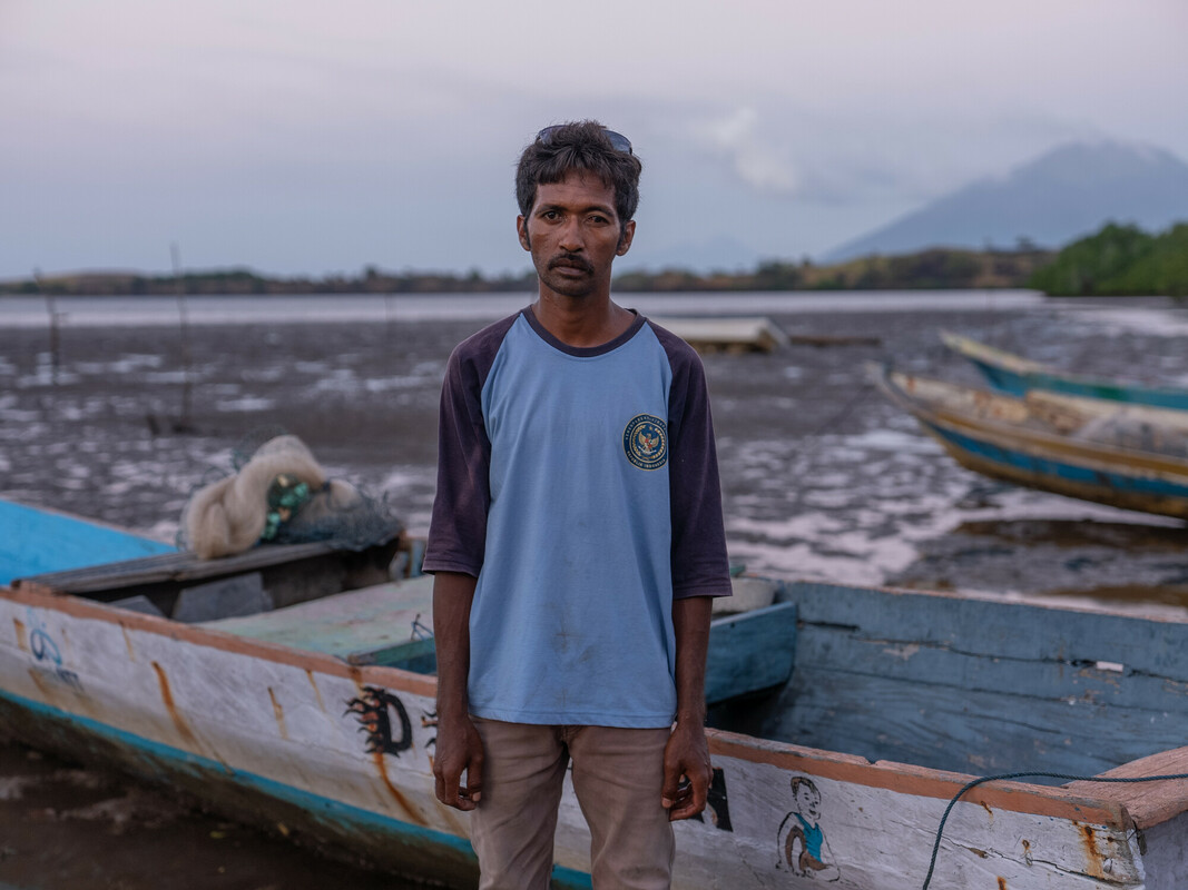 Mekko, Indonesia: Said (33) stands in front of his fishing boat. He now struggles to catch enough fish for his family's daily needs, due to climate change and the fish moving further and further out to sea. Oxfam acknowledges the support of the Australian Government through the Australian NGO Cooperation Program (ANCP). Photo: Vikram Sombu/Oxfam