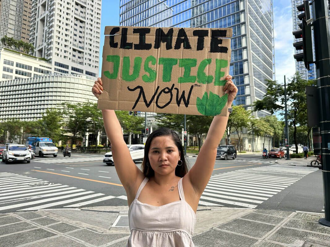 Manila, Philippines: Marinel holding a protest card in front of Shell HQ in Manilla, just like she used to do during the lobby for the petition to have a resolution on Fossil companies abusing human rights by fueling climate change with extractive and polluting activities. Stories4Change by Climate Tracker, Oxfam International