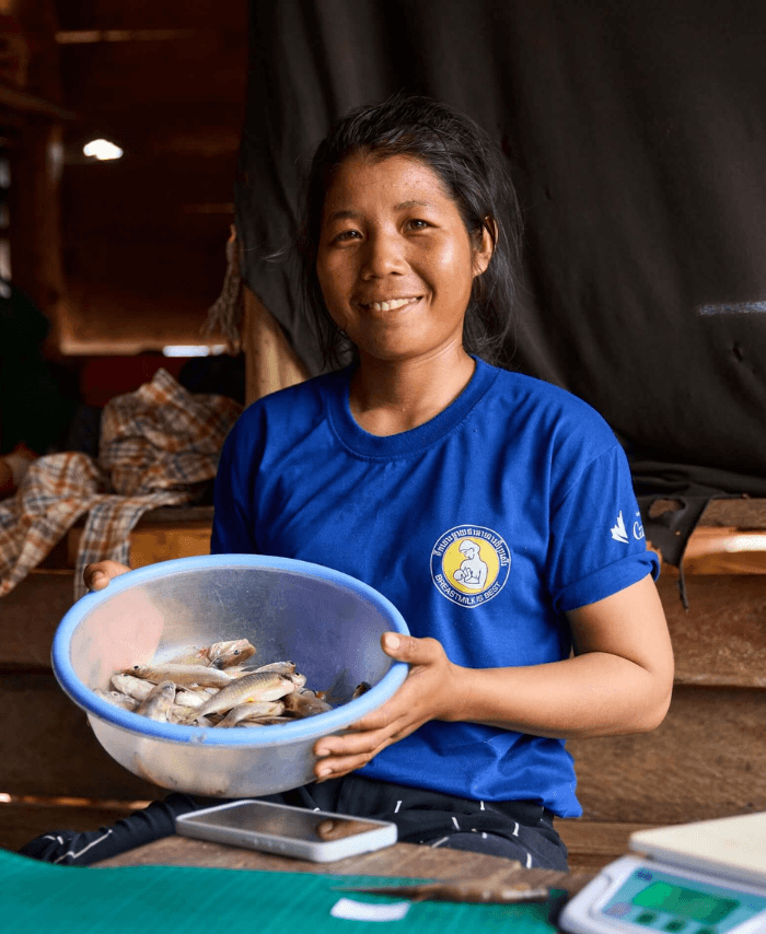 Cambodia: Chhorvy recording her catch for the day. Monitoring the catch of fish is important for the management and conservation of communities who depend on the lake for their nutrition, as well as providing indicators on ecological health of the water due to how sensitive fish are to water changes. Photo: Patrick Moran/Oxfam. Oxfam acknowledges the support of the Australian Government through the Department of Foreign Affairs and Trade (DFAT).