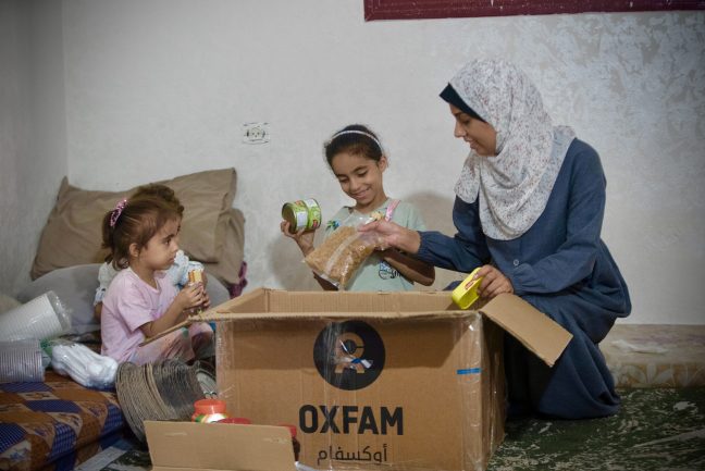 Gaza, Palestinian Territory, Occupied: Duaa Mansour and her children are checking the food items in Oxfam food parcel distributed among displaced people. She and her husband are challenged to make food for their three children who lost significant weighs during the Israel's war on Gaza. Photo: Alef Multimedia Company/Oxfam